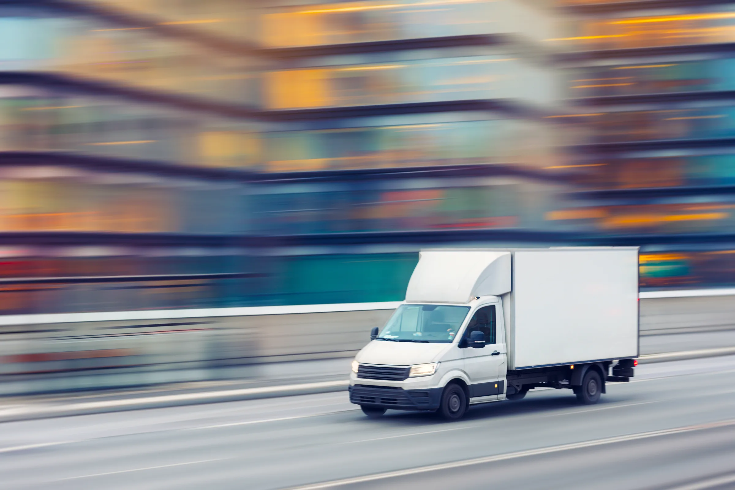 A delivery truck travels through downtown city streets.