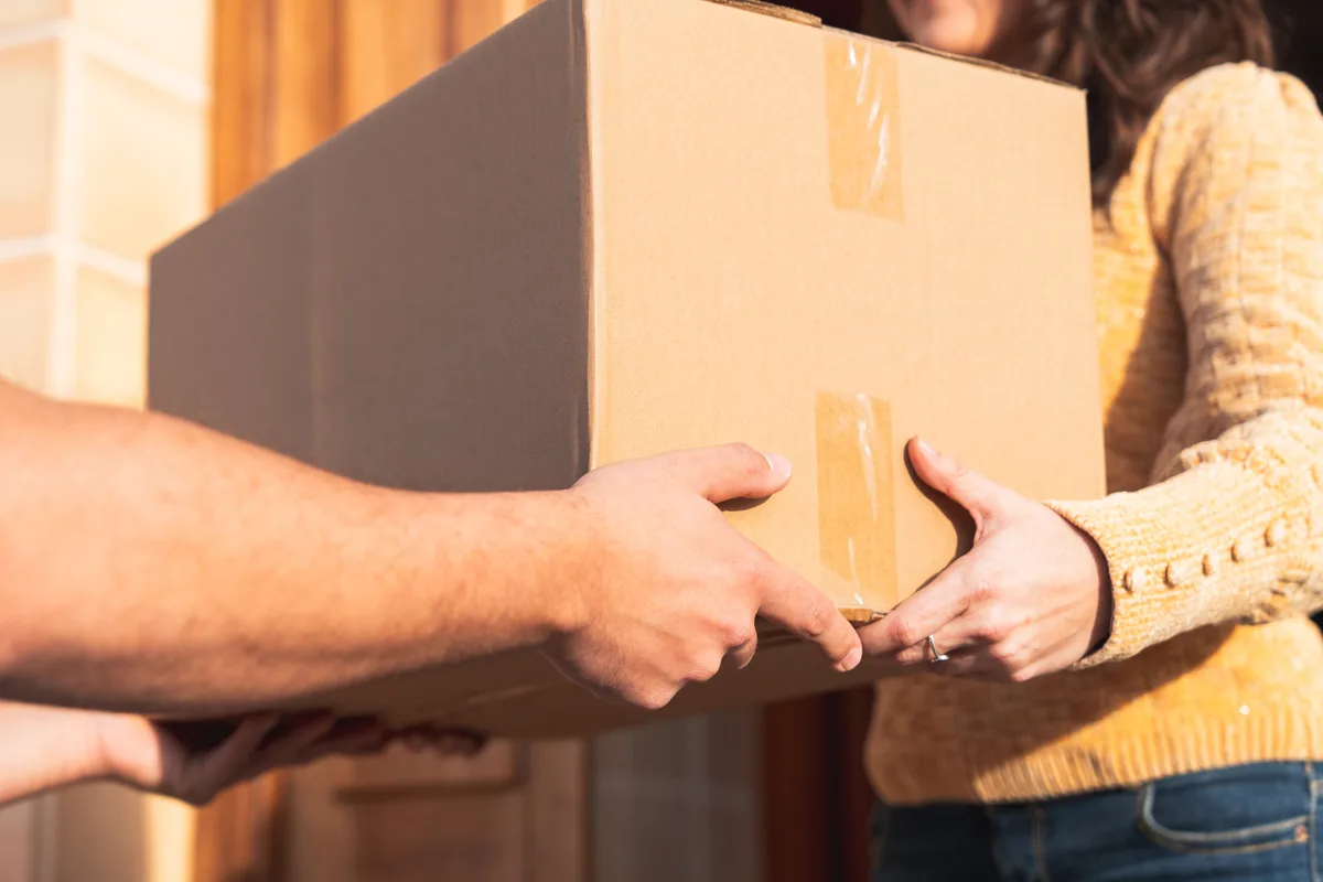 A package changes hands at a commercial doorstep.