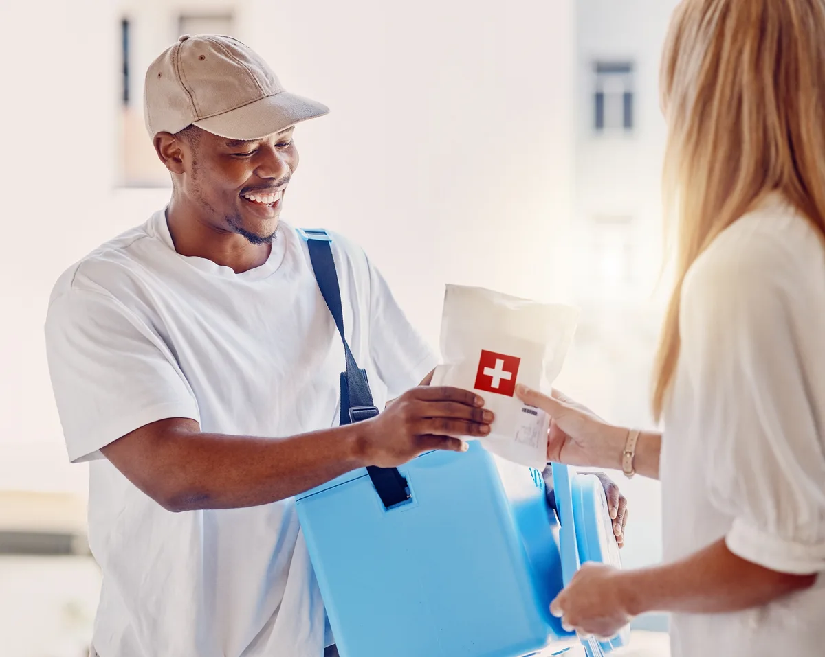 A courier hands over a delivery of medical supplies at a healthcare facility.